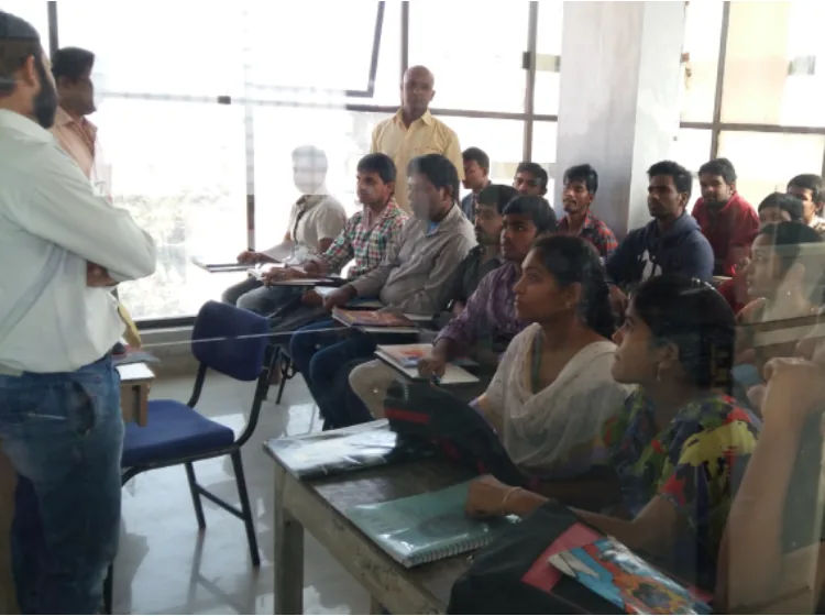 A trainer guiding students in an SV Infotech classroom